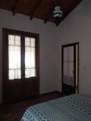 a bedroom with a bed and two windows and a ceiling at La arbolada in Villa Ciudad Parque