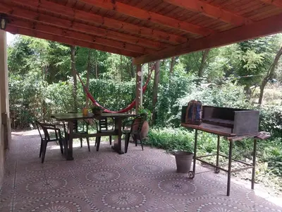 a screened porch with a table and a piano at La arbolada in Villa Ciudad Parque