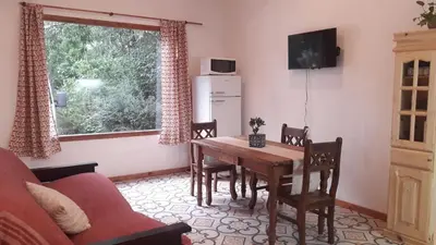 a living room with a table and chairs and a television at La arbolada in Villa Ciudad Parque