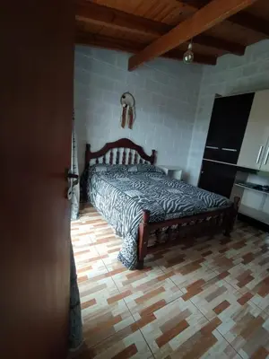 a bed in a bedroom with a wooden floor at Nápoles in Santa Rosa de Calamuchita