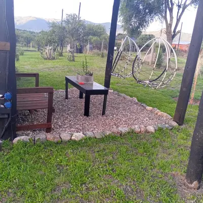 a table and a bench in a park with a playground at Nápoles in Santa Rosa de Calamuchita