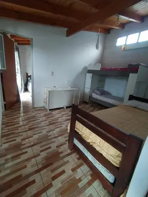 a room with two bunk beds and a wooden floor at Nápoles in Santa Rosa de Calamuchita