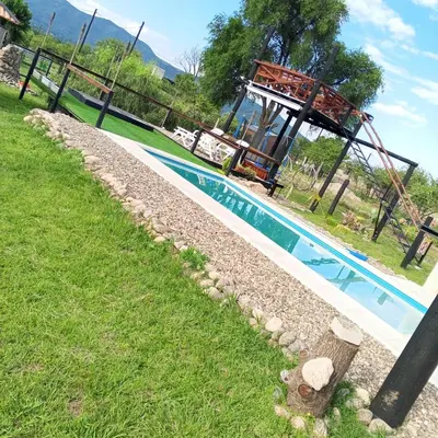 a swimming pool in a yard with a grassy field at Nápoles in Santa Rosa de Calamuchita