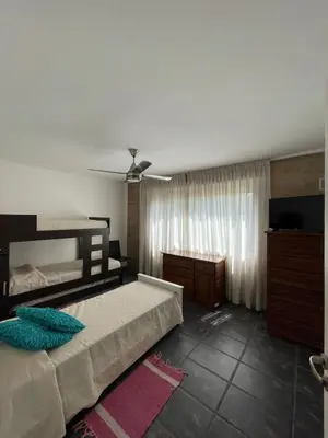 a bedroom with two beds and a ceiling fan at Casa Rumipal in Villa Rumipal