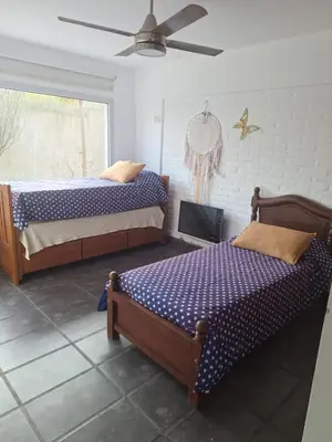 a bedroom with two beds and a ceiling fan at Casa Rumipal in Villa Rumipal