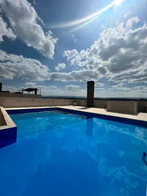 a large blue swimming pool on top of a building at Dpto con piscina , asador & terraza in Villa Carlos Paz