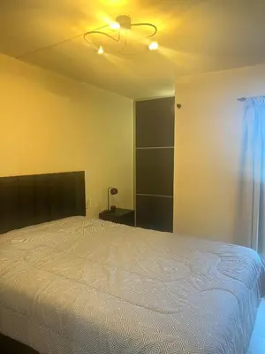 a bedroom with a white bed and a ceiling at Dpto con piscina , asador & terraza in Villa Carlos Paz