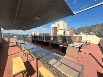 a glass table and chairs on a roof at Dpto con piscina , asador & terraza in Villa Carlos Paz