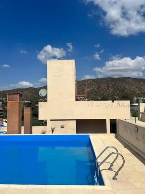 a swimming pool on the roof of a house at Dpto con piscina , asador & terraza in Villa Carlos Paz