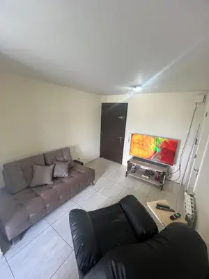 a living room with a couch and a tv at Dpto con piscina , asador & terraza in Villa Carlos Paz