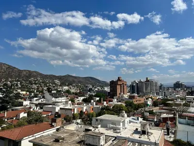a view of a city with buildings and mountains at Dpto con piscina , asador & terraza in Villa Carlos Paz