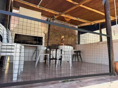 a group of white chairs and a table on a patio at Las Casitas de Euge in Villa Carlos Paz