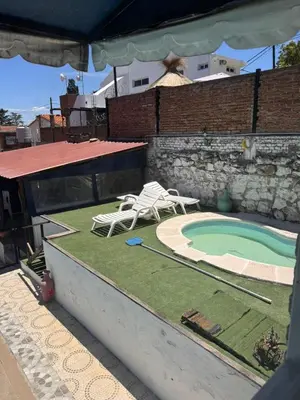 a backyard with a swimming pool and two lawn chairs at Las Casitas de Euge in Villa Carlos Paz