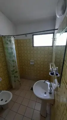 a bathroom with a sink and a toilet and a window at Gran Malvina in Villa Carlos Paz
