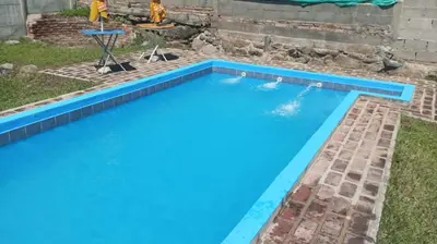 a swimming pool in the yard with a blue pool at Gran Malvina in Villa Carlos Paz