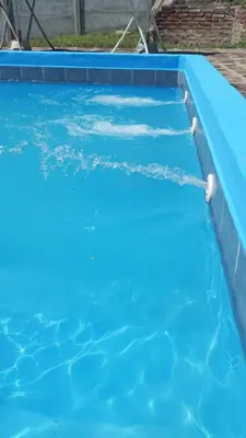 a swimming pool with blue water in a yard at Gran Malvina in Villa Carlos Paz