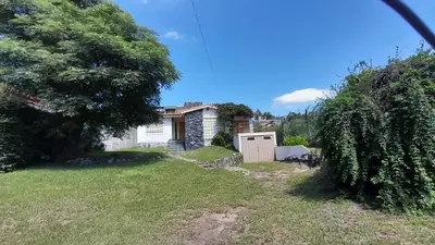 a house with a fence and a yard at Gran Malvina in Villa Carlos Paz