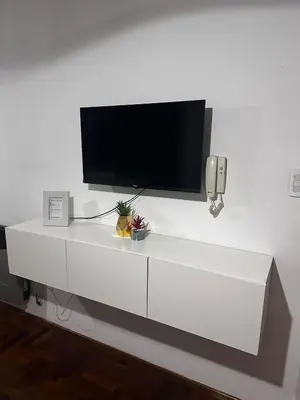 a white entertainment center with a flat screen tv on a wall at Carlis Home in Cordoba