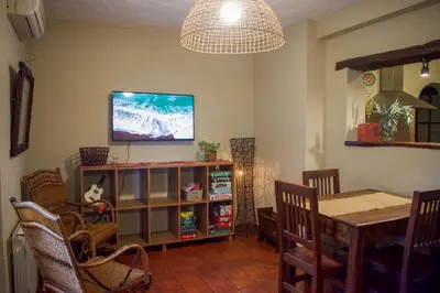 a dining room with a table and a television on a wall at Posada serrana boutique con excelentes vistas cerca de arroyos y senderos y a 5 minutos de Merlo in El Rincón