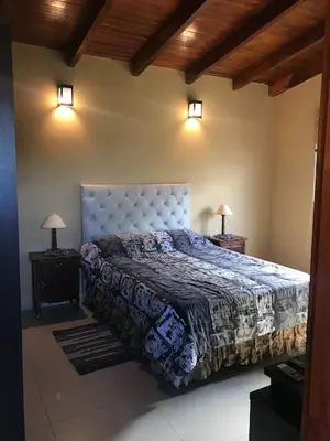 a bedroom with a large bed with two night stands at Departamento Los Gigantes in Villa Carlos Paz