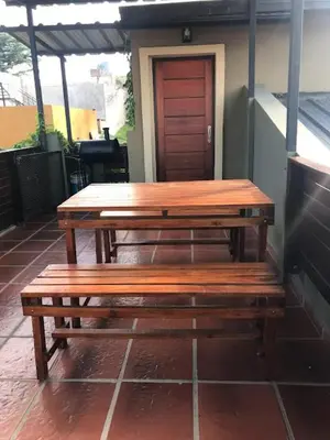 a wooden table and benches on a patio at Departamento Los Gigantes in Villa Carlos Paz
