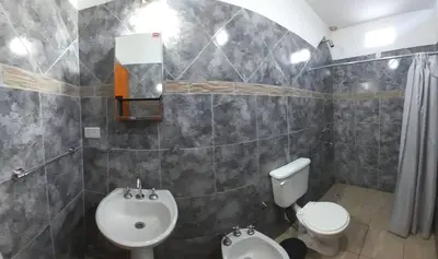 a bathroom with a toilet and a sink at Complejo Cuarto Menguante in Arroyo de Los Patos