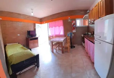 a kitchen with a bed and a table and a refrigerator at Complejo Cuarto Menguante in Arroyo de Los Patos