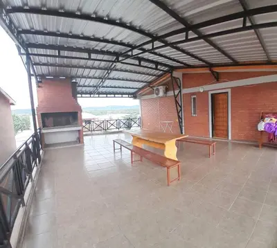 a patio with benches and a table on a building at Complejo Cuarto Menguante in Arroyo de Los Patos
