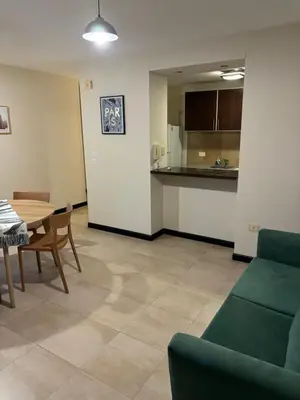 a living room with a table and a kitchen at Departamento amoblado 1 dormitorio Río 4 in Río Cuarto