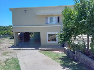 a white house with a window and a yard at Casa florez in Mina Clavero