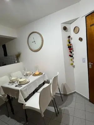 a dining room with a table and a clock on the wall at illia home in Cordoba