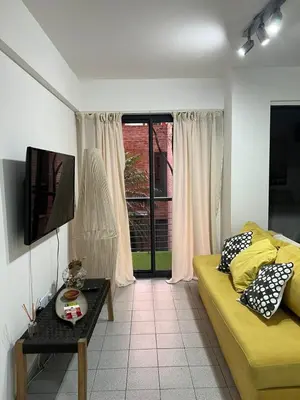 a living room with a yellow couch and a window at illia home in Cordoba