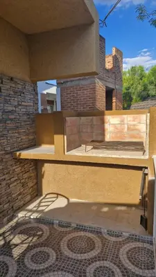 a patio with a table and a brick building at Dúplex La Delfina 3 in Villa Carlos Paz