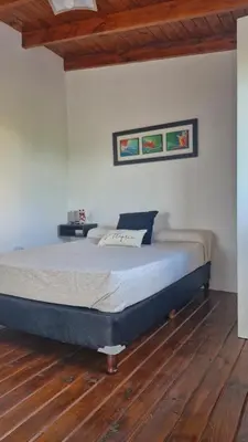 a bedroom with a bed and a wooden floor at Dúplex La Delfina 3 in Villa Carlos Paz