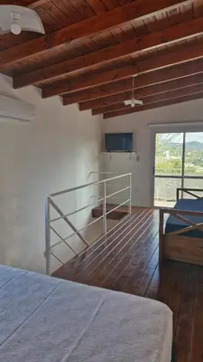 a bedroom with a bed and a staircase in a room at Dúplex La Delfina 3 in Villa Carlos Paz
