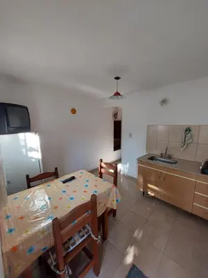 a room with a table and a kitchen with a sink at Propiedades Centro MC in Mina Clavero