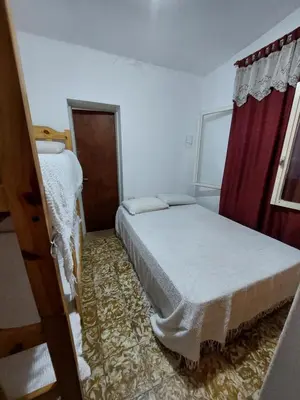 a small bedroom with a bed and a window at Propiedades Centro MC in Mina Clavero