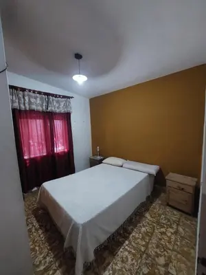 a bedroom with a white bed and red curtains at Propiedades Centro MC in Mina Clavero