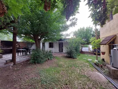 a backyard of a house with a table and a tree at Propiedades Centro MC in Mina Clavero