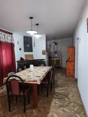 a dining room with a table and chairs and a kitchen at Propiedades Centro MC in Mina Clavero