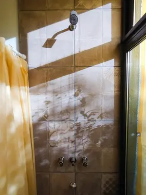 a shower with a shower head in a bathroom at Refugio Verde en Nono, Córdoba in Nono