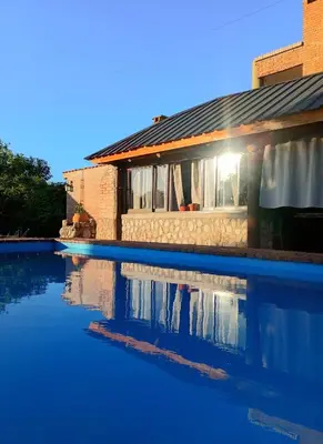 a house with a swimming pool in front of a house at Refugio Verde en Nono, Córdoba in Nono