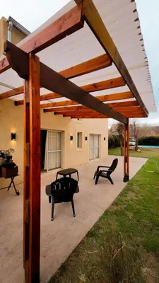 a wooden pergola with two benches on a patio at Casa Moraa in Nono