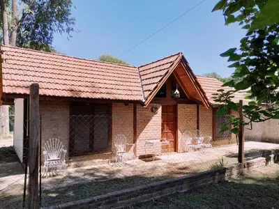 a house with chairs in front of it at Vistas valle in Santa Rosa de Calamuchita