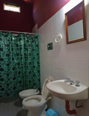 a bathroom with a sink and a toilet and a mirror at Alojamiento Quilo in Merlo