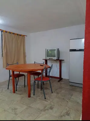 a kitchen with a wooden table with chairs and a refrigerator at Alojamiento Quilo in Merlo