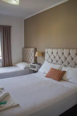 a hotel room with two beds and a window at Realty vacacional 61 in Villa Carlos Paz