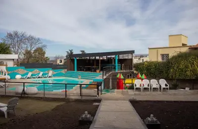 a swimming pool with chairs and a building at Realty vacacional 61 in Villa Carlos Paz