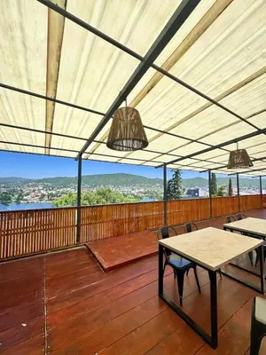 a covered deck with tables and chairs and lights at Realty vacacional 61 in Villa Carlos Paz