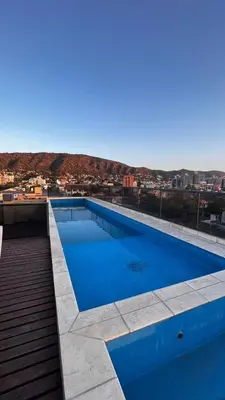 a blue swimming pool on top of a building at Dto con pileta en Carlos Paz 28! in La Cuesta